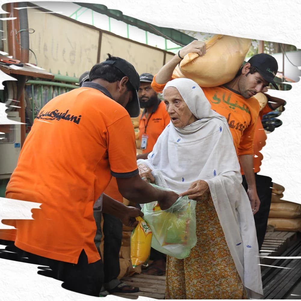 Saylani volunteers distributing ration packages to families